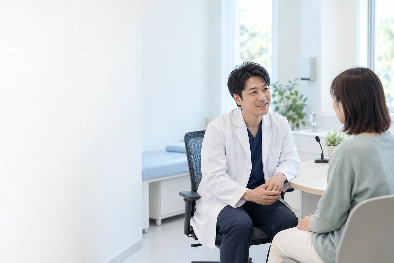 明るい診察室で、医師が患者さんと向き合って話している